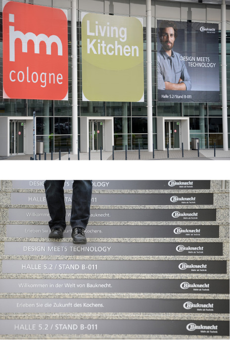 Drei Poster vor einem Messeeingang und Werbemöglichkeiten auf Treppenstufen