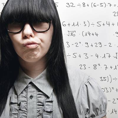 Young woman in front of a blackboard with math formulas