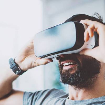 Mann setzt eine Virtual Reality Brille auf